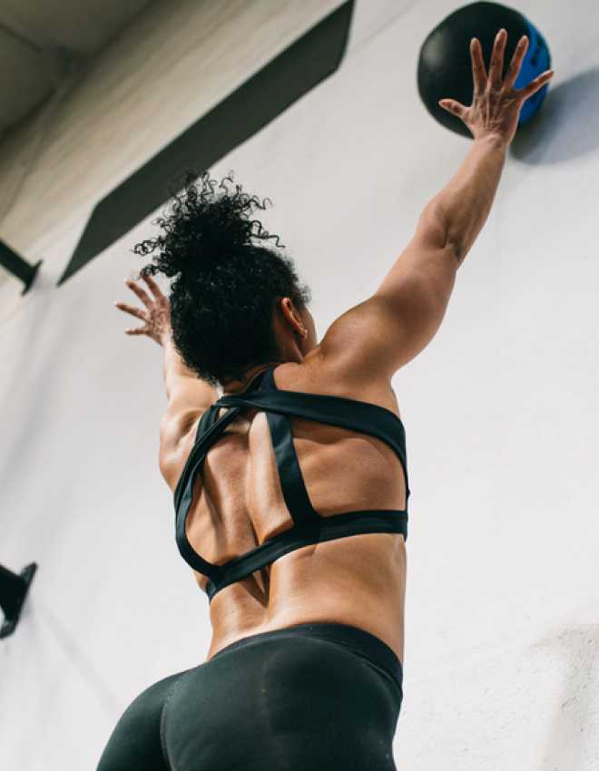 Woman throwing weighted ball against wall