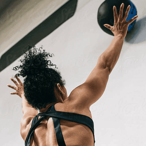 Woman throwing weighted ball against wall