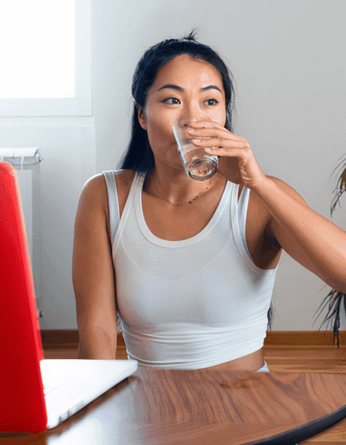 Woman drinking glass of water indoors