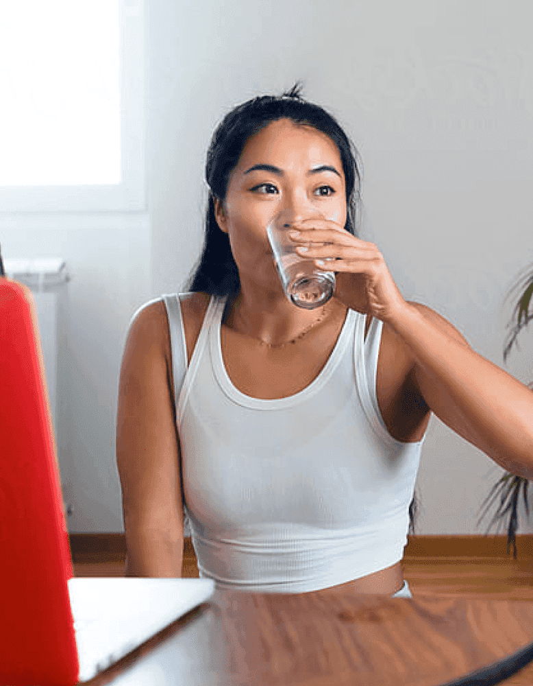 Woman drinking glass of water indoors